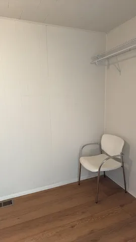 a view of a room with wooden floor and a chair
