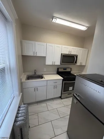 a kitchen with a sink a stove top oven and cabinets