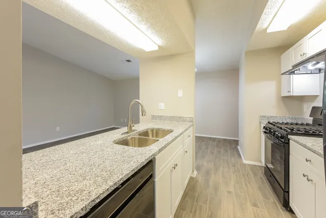 a kitchen with stainless steel appliances granite countertop a refrigerator and a stove