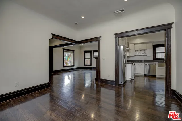 a view of a hallway with wooden floor and a living room