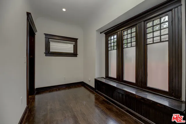 a view of a hallway with wooden floor and closet