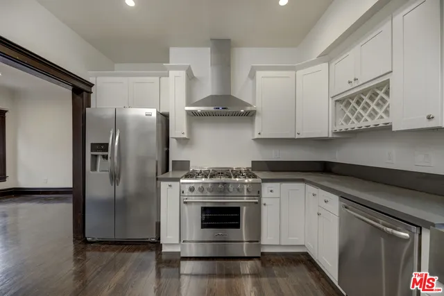 a kitchen with granite countertop white cabinets and white appliances