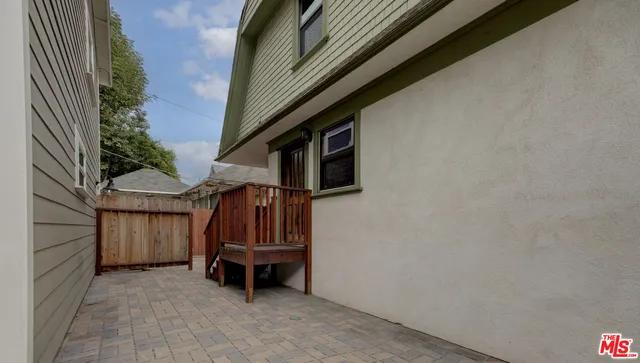 a view of backyard with small cabin and wooden fence