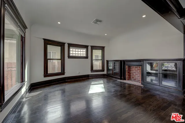 an empty room with wooden floor and a fireplace