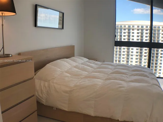 a bed sitting in a bedroom next to a window