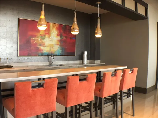 a kitchen with stainless steel appliances granite countertop a sink a stove a dining table and chairs