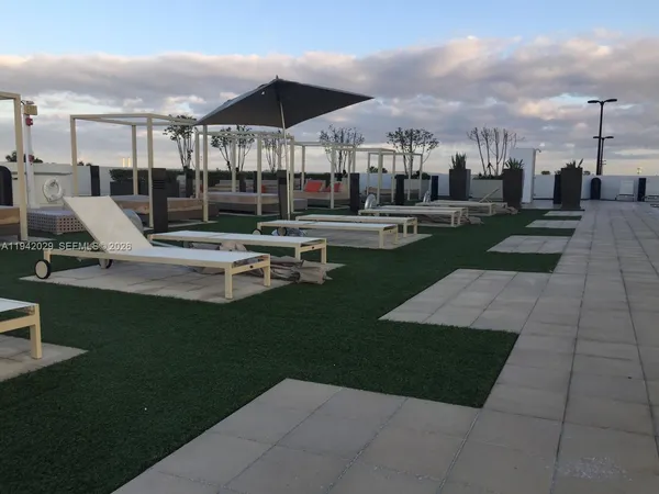 a view of a patio with a table chairs and a fire pit