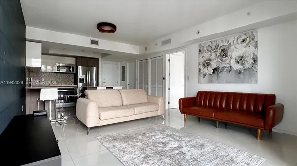 a living room with furniture a couch and a dining table with wooden floor