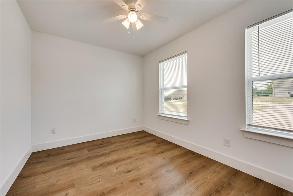 126 Lynn Court, Unit 100 Decatur, TX 76234 - Photo 13 of 20 a view of an empty room with wooden floor and a window