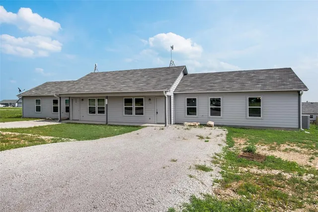 a view of a house with a yard and large tree