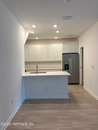 a view of kitchen with stainless steel appliances granite countertop a refrigerator and a sink