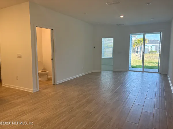 an empty room with wooden floor and a window