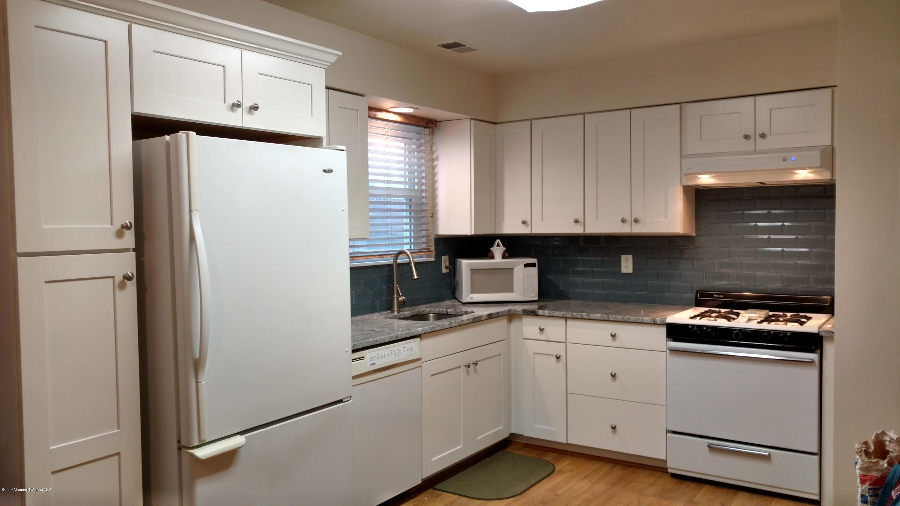 296 Greenwood Loop Road Brick, NJ 08724 - Photo 2 of 15 a kitchen with white cabinets and white appliances