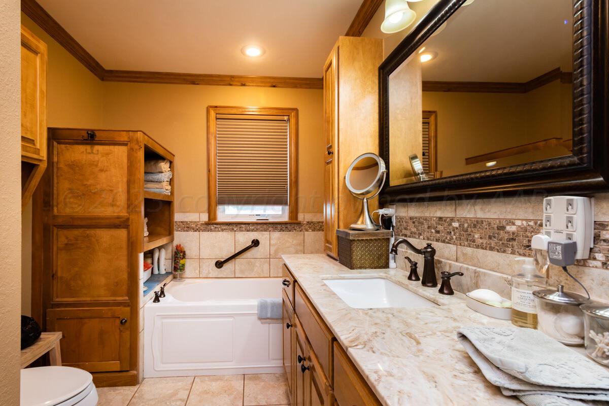 Flowers Ranch Miami, TX 79059 - Photo 185 of 285 a bathroom with a granite countertop toilet sink and mirror