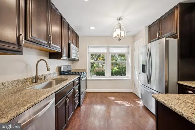 a kitchen with stainless steel appliances granite countertop a sink refrigerator and microwave