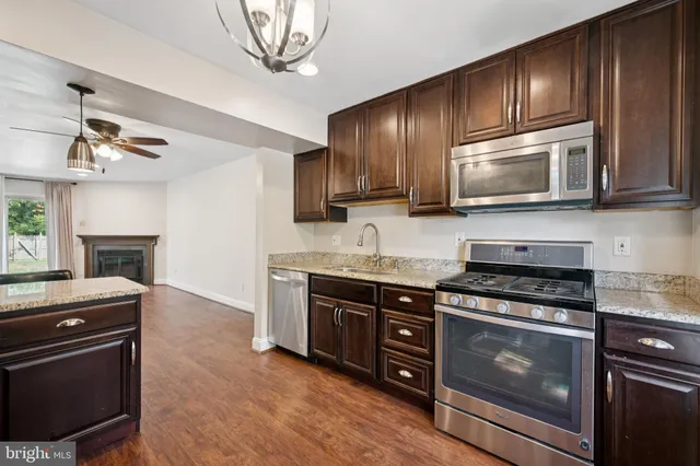 a kitchen with granite countertop wooden cabinets and stainless steel appliances