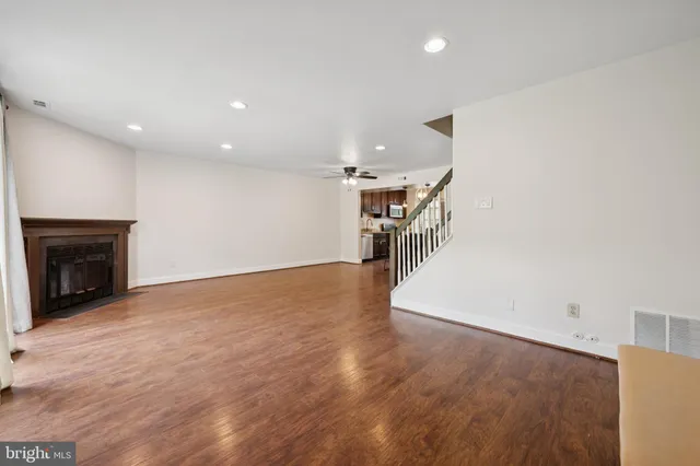 an empty room with wooden floor and fireplace