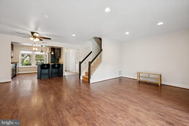 a view of empty room with wooden floor and windows