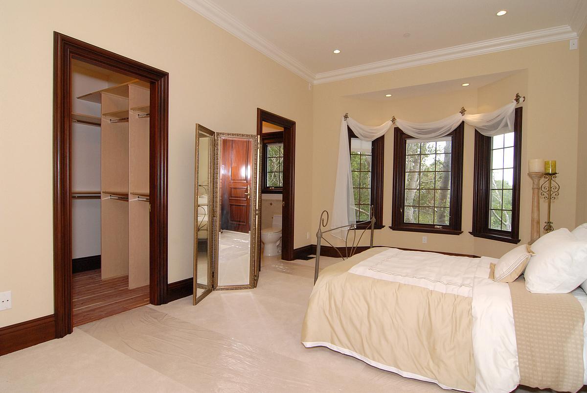 630 Pullman Road Hillsborough, CA 94010 - Photo 16 of 24 a spacious bedroom with a bed and a large mirror