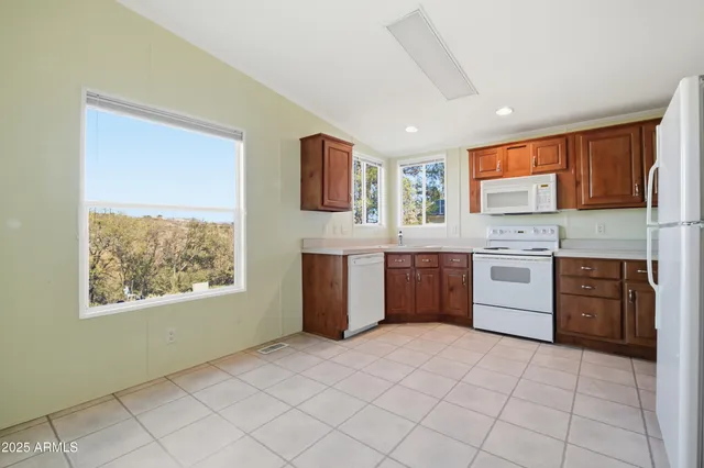 an empty room with windows and ceiling fan