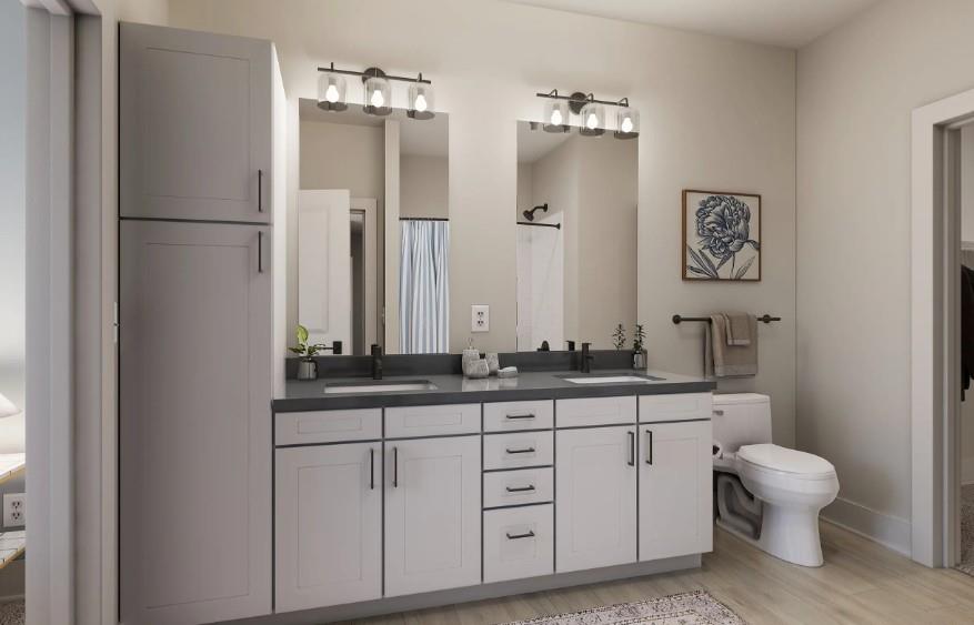 1400 Laurel Crossing Parkway Northeast, Unit 1105 Buford, GA 30519 - Photo 11 of 33 a bathroom with a granite countertop sink a toilet and a mirror