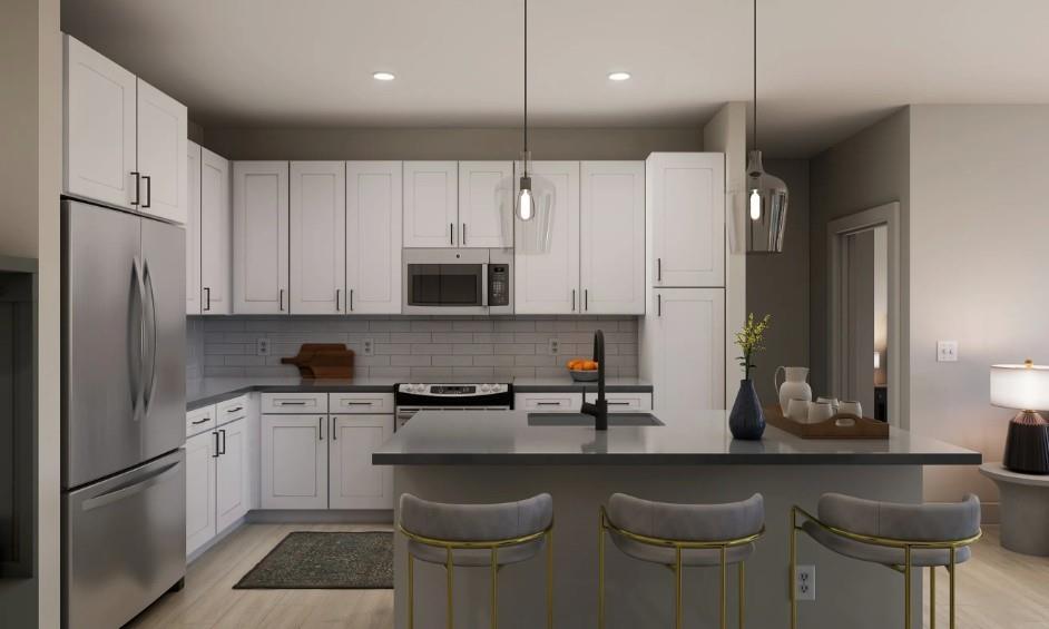 1400 Laurel Crossing Parkway Northeast, Unit 1105 Buford, GA 30519 - Photo 4 of 33 a kitchen with stainless steel appliances a sink a stove a refrigerator and cabinets