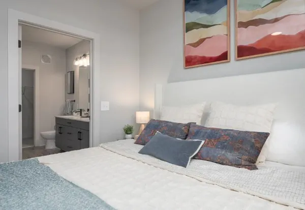 a bedroom with a large bed and chandelier