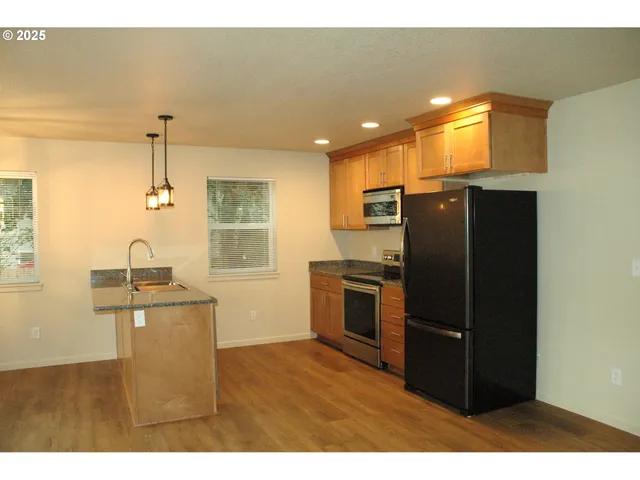 a kitchen with granite countertop a refrigerator and a stove