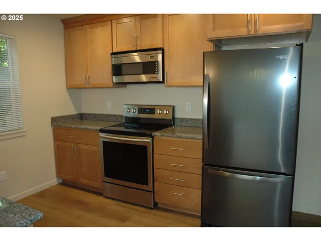 a kitchen with stainless steel appliances granite countertop a refrigerator and a microwave