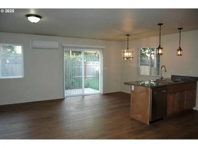a view of kitchen and hall with wooden floor