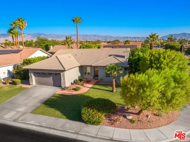 a view of a house with a yard and potted plants
