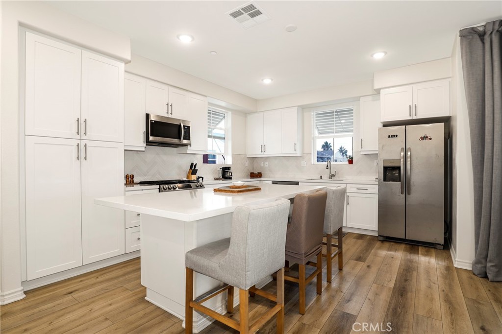 1380 Vigilant Carson, CA 90746 - Photo 1 of 43 a kitchen with a sink a microwave a refrigerator and cabinets