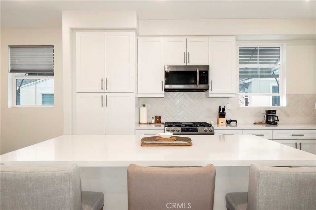 1380 Vigilant Carson, CA 90746 - Photo 3 of 43 a kitchen with stainless steel appliances a stove a microwave and white cabinets