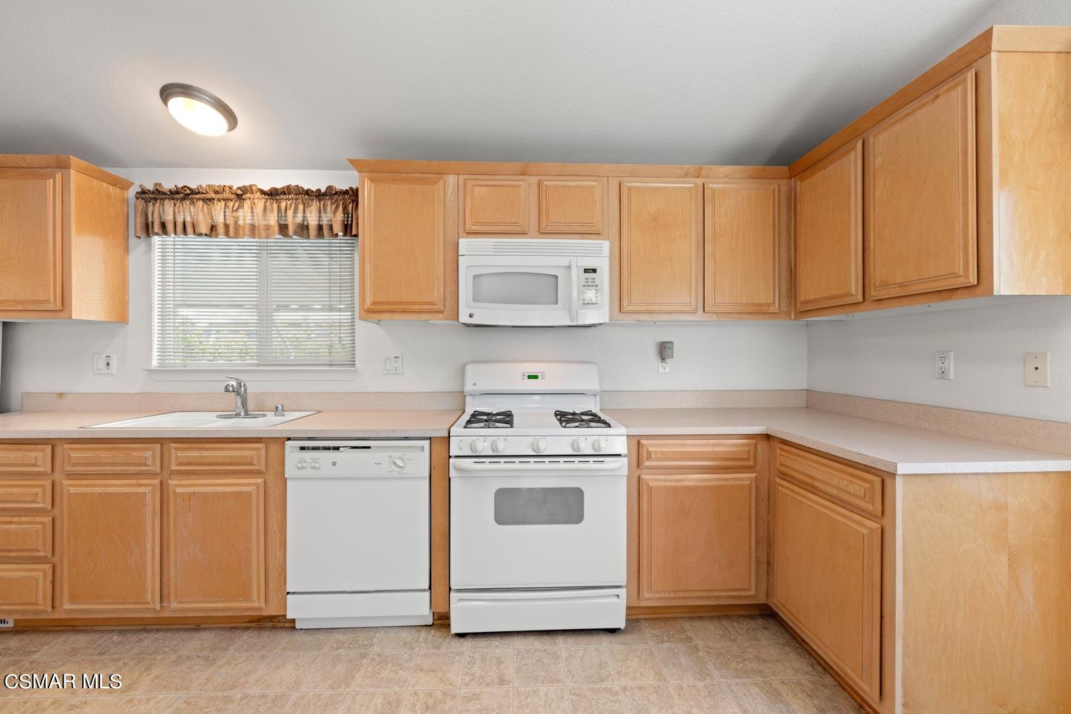 195 Tierra Rejada Road, Unit 155 Simi Valley, CA 93065 - Photo 16 of 33 a kitchen with cabinets appliances a sink and a window
