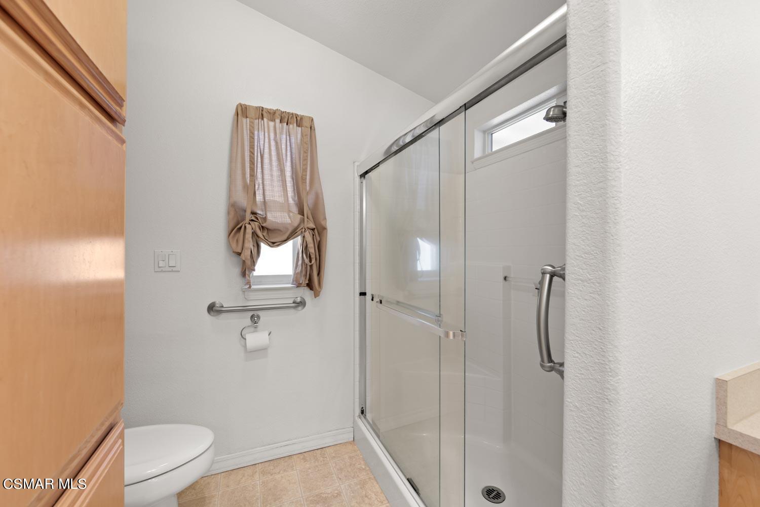 195 Tierra Rejada Road, Unit 155 Simi Valley, CA 93065 - Photo 26 of 33 a bathroom with a granite countertop sink a toilet and shower