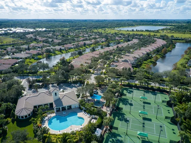 an aerial view of residential houses with outdoor space and trees