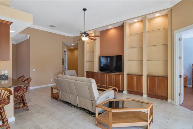 a living room with furniture a flat screen tv and a window
