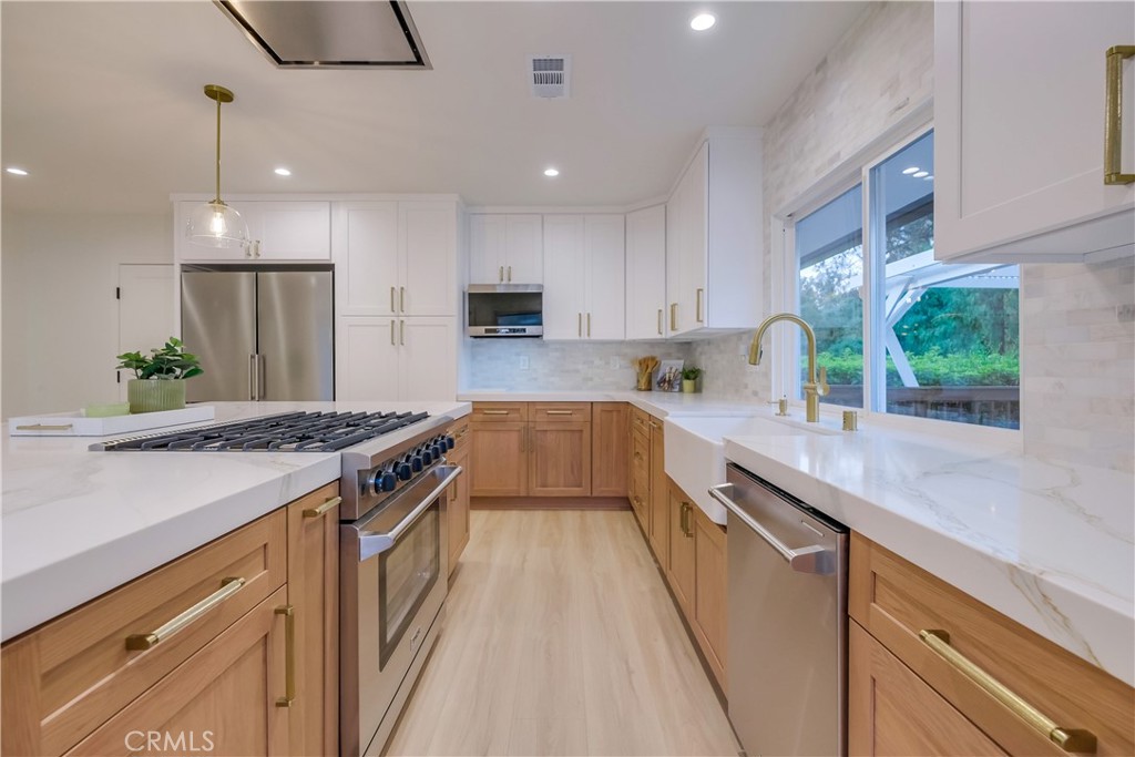 5205 Middlecrest Road Rancho Palos Verdes, CA 90275 - Photo 13 of 63 a kitchen with kitchen island granite countertop a stove a sink a refrigerator and a counter top space