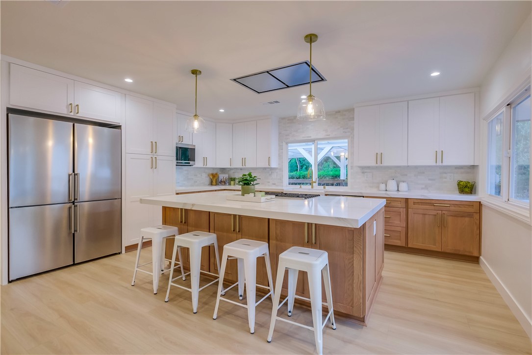 5205 Middlecrest Road Rancho Palos Verdes, CA 90275 - Photo 4 of 63 a kitchen with kitchen island granite countertop a table chairs stove microwave and cabinets