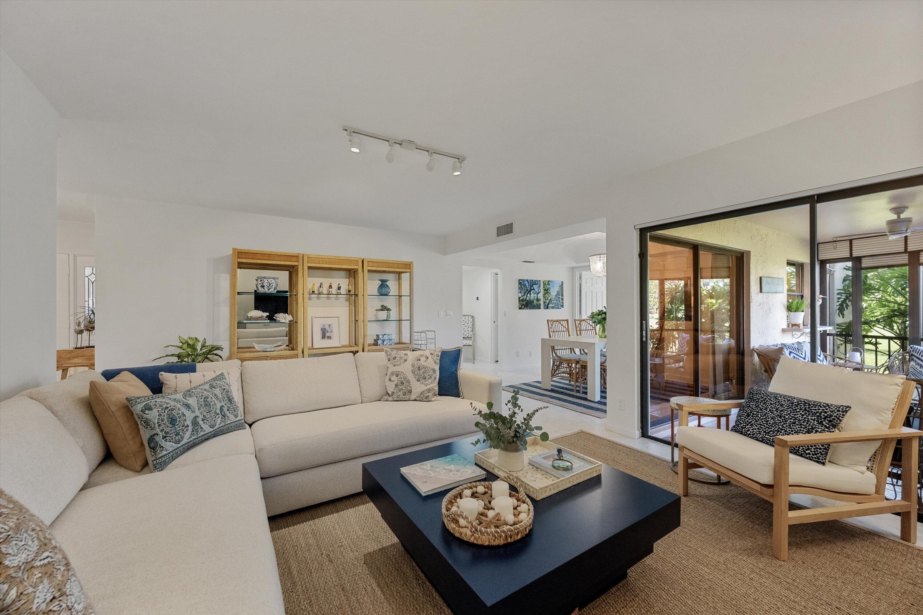 a living room with furniture potted plant and a large window