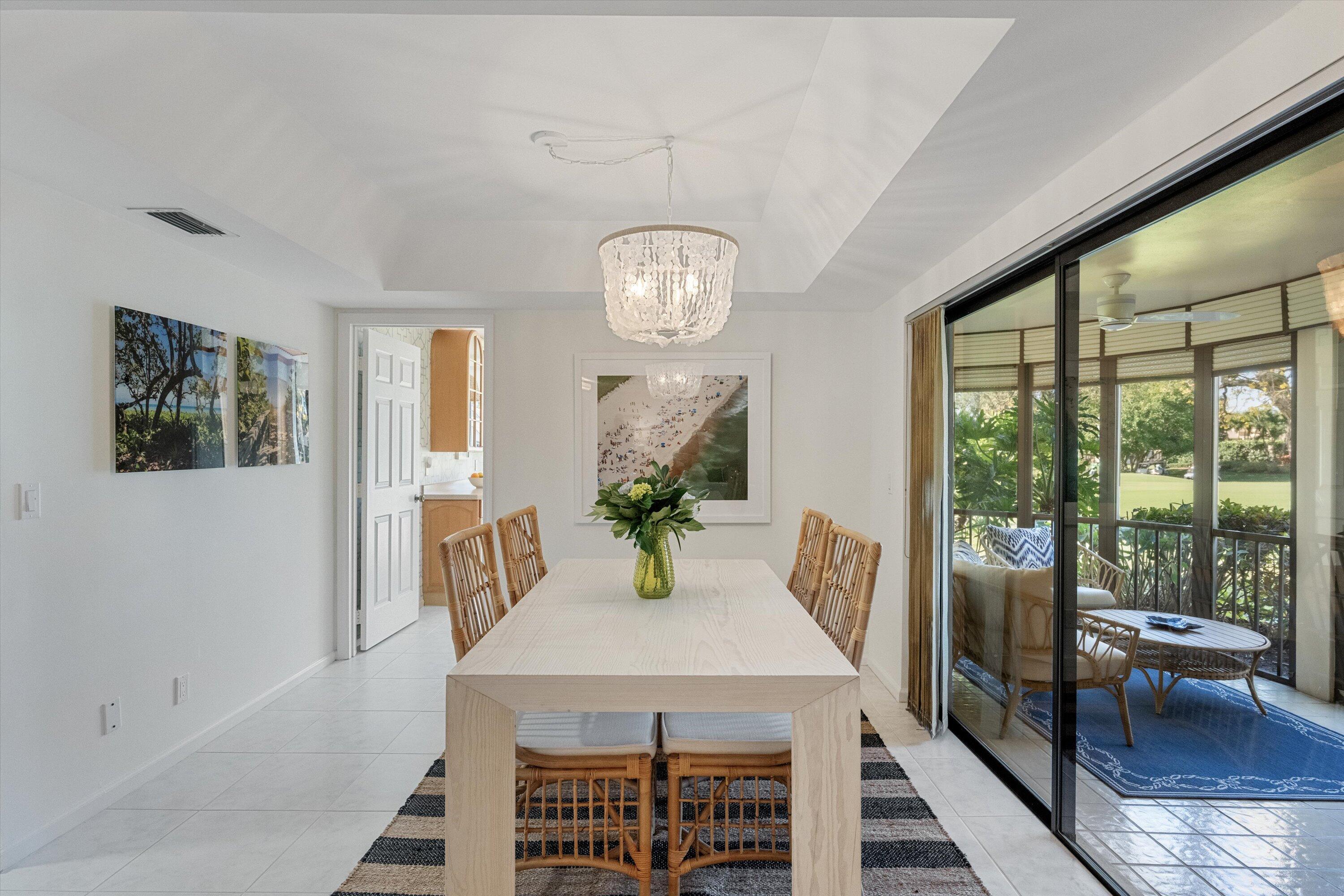 17166 Waterbend Drive, Unit 111 Jupiter, FL 33477 - Photo 11 of 34 a view of a dining room with furniture a chandelier and wooden floor