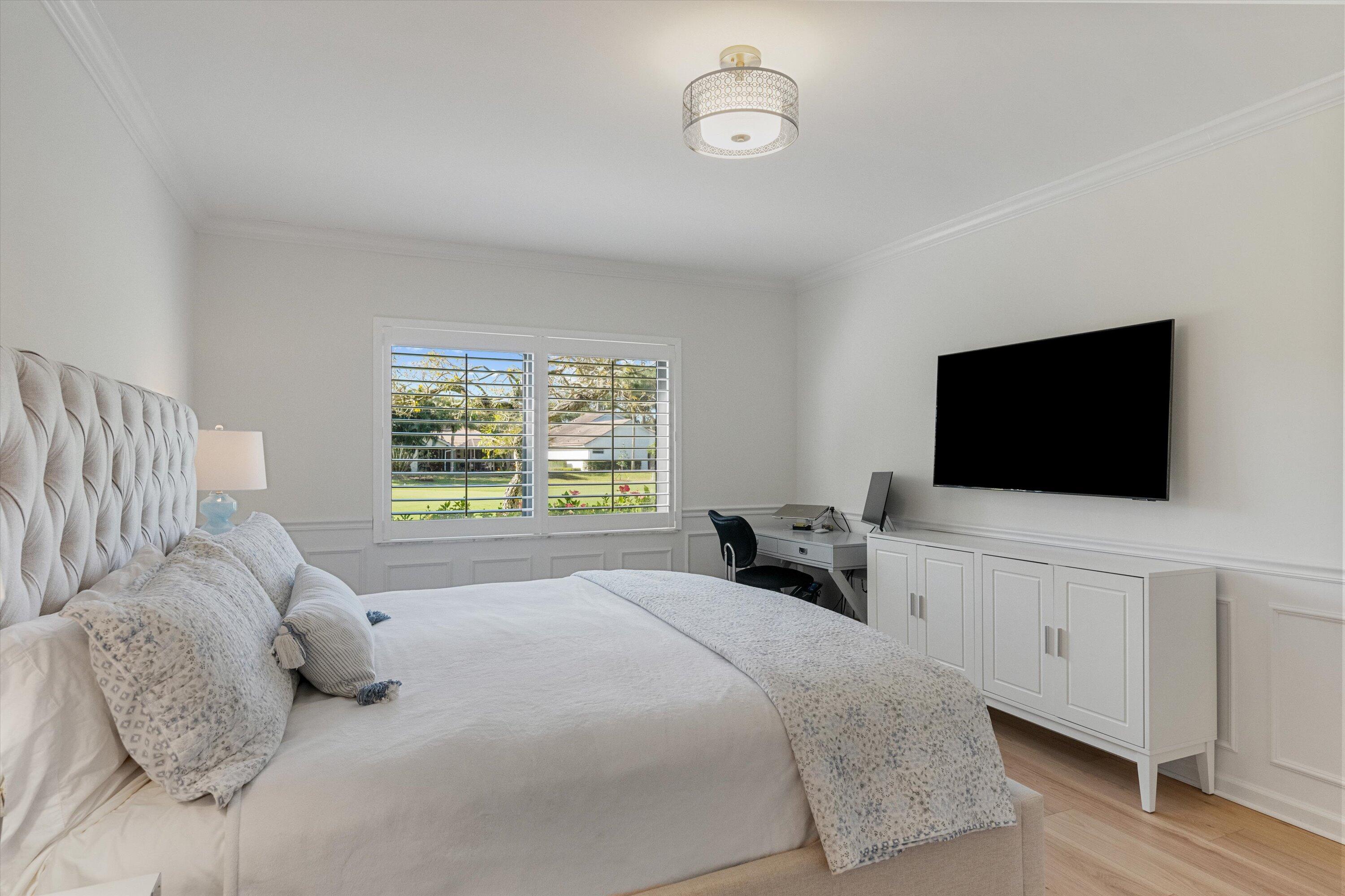 17166 Waterbend Drive, Unit 111 Jupiter, FL 33477 - Photo 17 of 34 a bedroom with a bed a tv and wooden floor