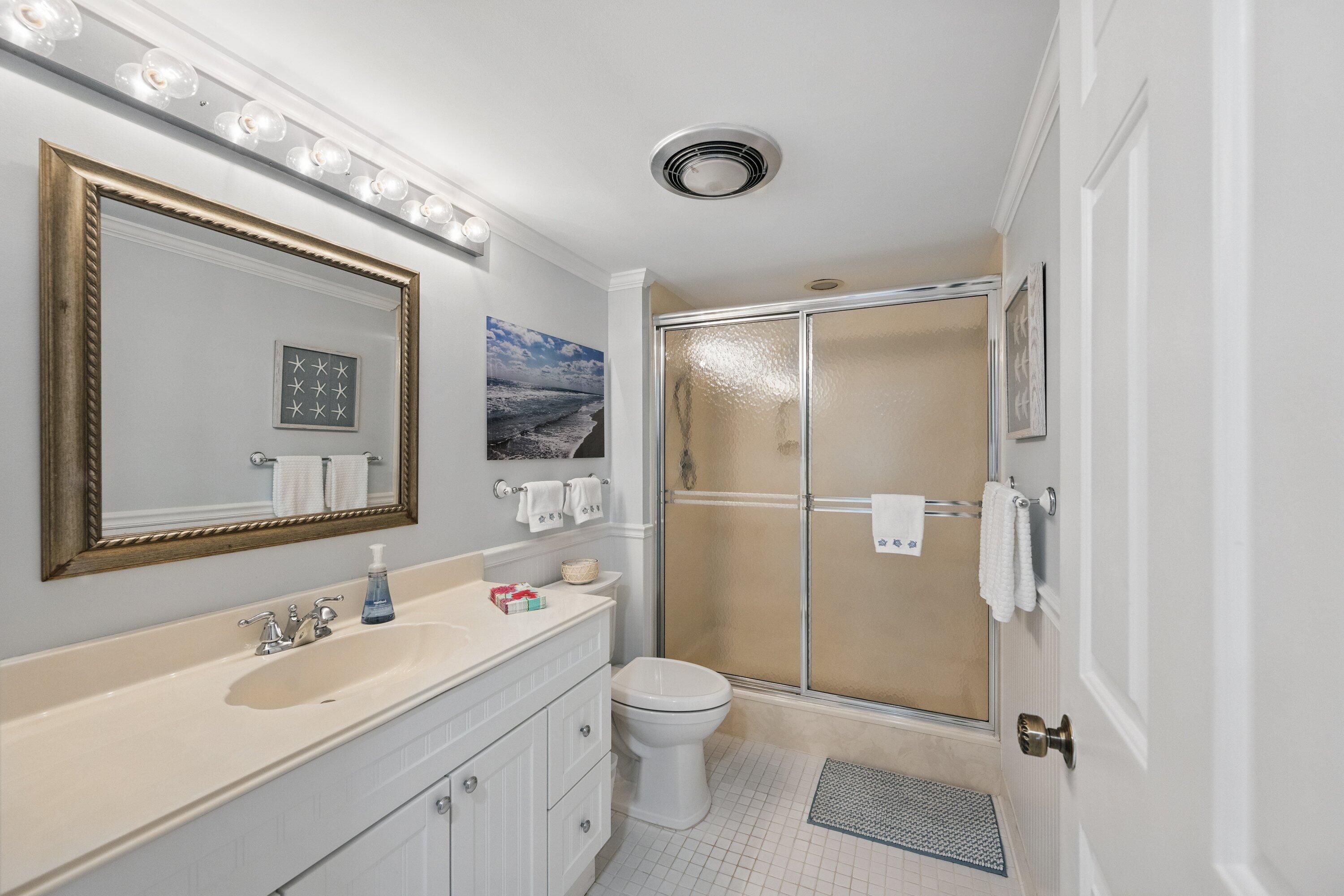 17166 Waterbend Drive, Unit 111 Jupiter, FL 33477 - Photo 23 of 34 a bathroom with a double vanity sink toilet mirror and shower