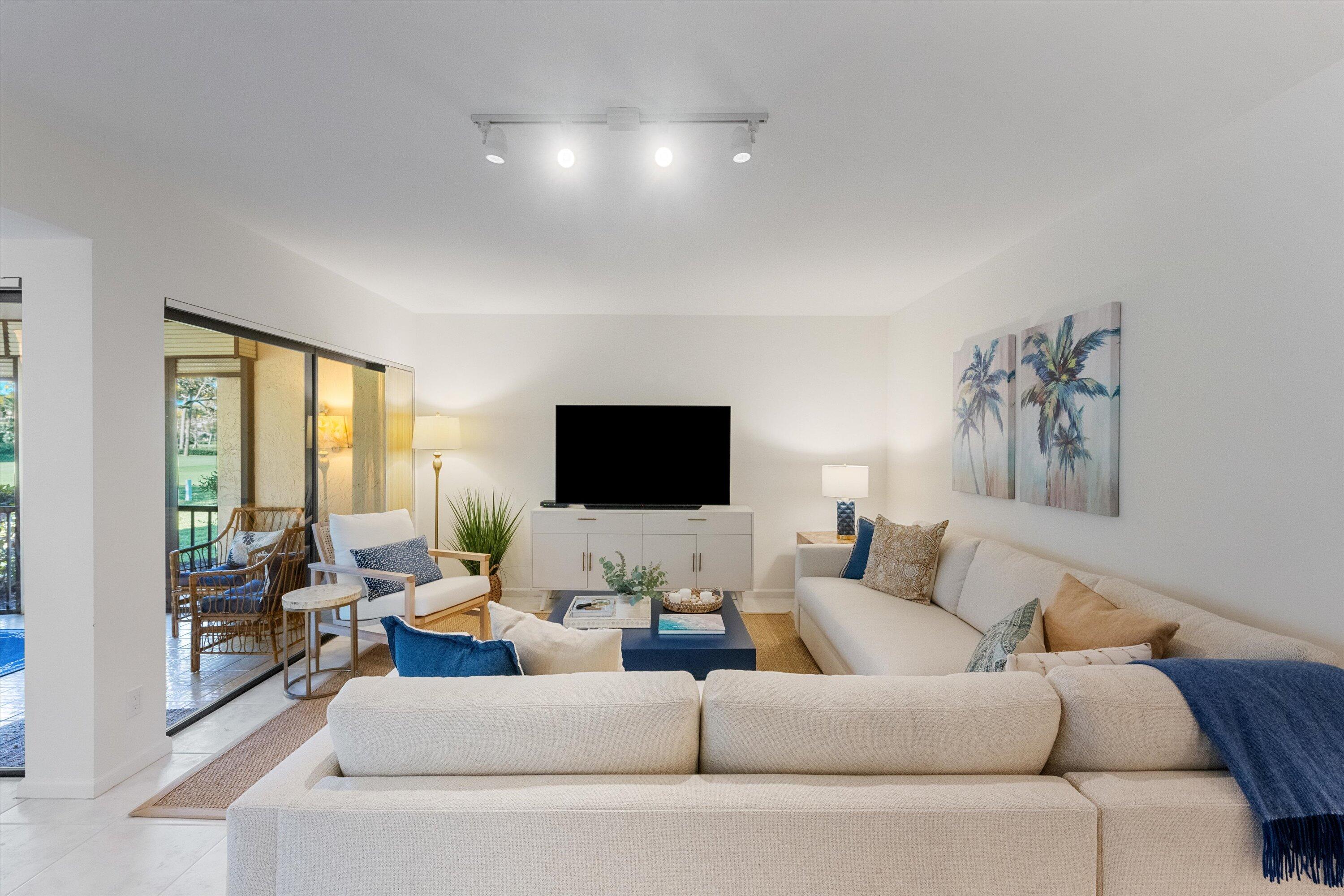 17166 Waterbend Drive, Unit 111 Jupiter, FL 33477 - Photo 7 of 34 a living room with furniture and a flat screen tv