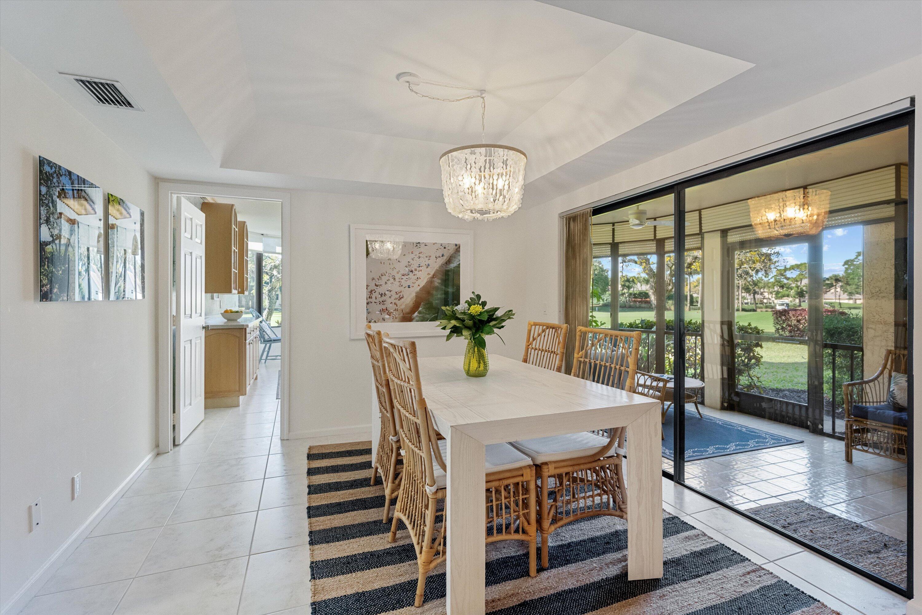 17166 Waterbend Drive, Unit 111 Jupiter, FL 33477 - Photo 10 of 34 a view of a dining room with furniture large windows and wooden floor