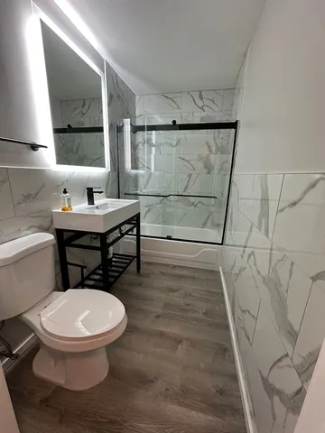 a bathroom with a toilet a sink and mirror