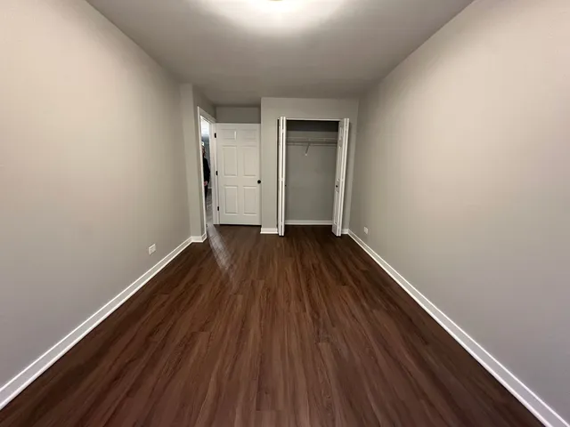 a view of a room with wooden floor and white walls