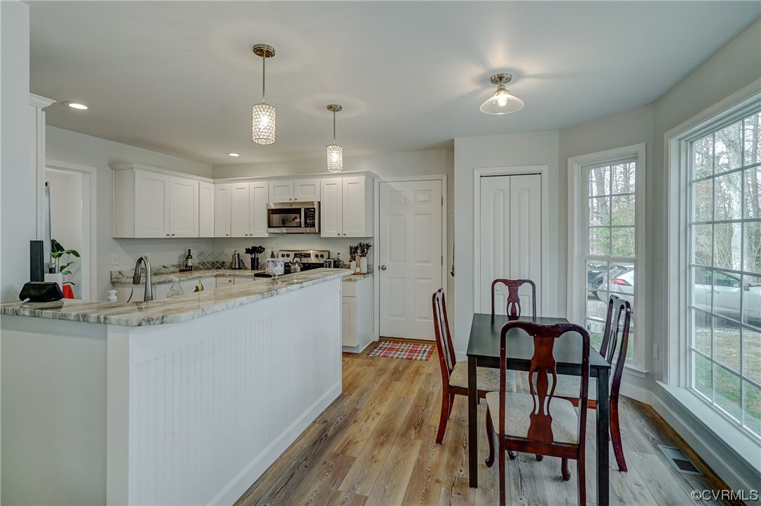 3334 Three Chopt Road Gum Spring, VA 23065 - Photo 10 of 44 a kitchen with stainless steel appliances granite countertop a dining table chairs refrigerator and microwave