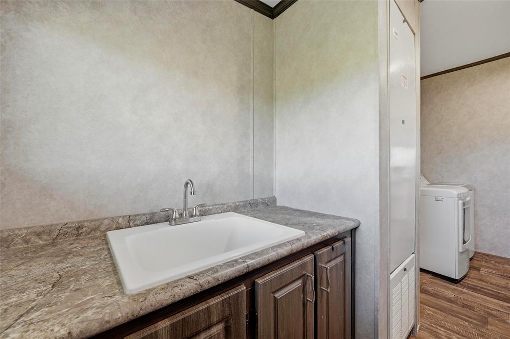 1113 Caroline Court Howe, TX 75459 - Photo 13 of 32 a bathroom with a granite countertop sink and a mirror