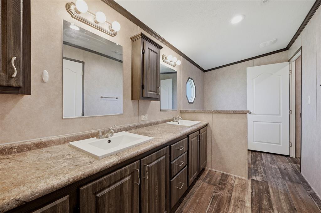1113 Caroline Court Howe, TX 75459 - Photo 16 of 32 a bathroom with a granite countertop sink a mirror and vanity